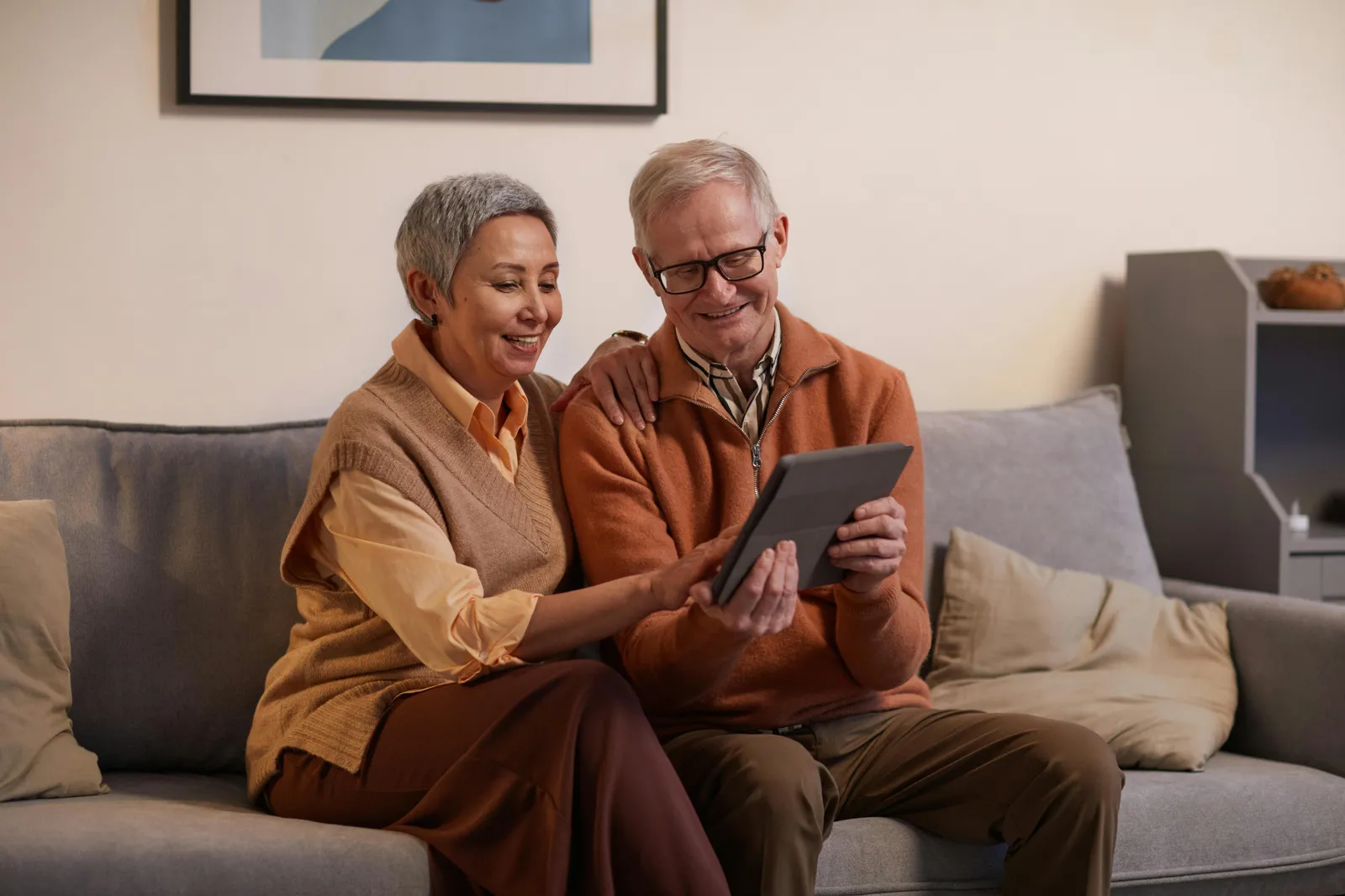 Senior couple learning to use a tablet together at home